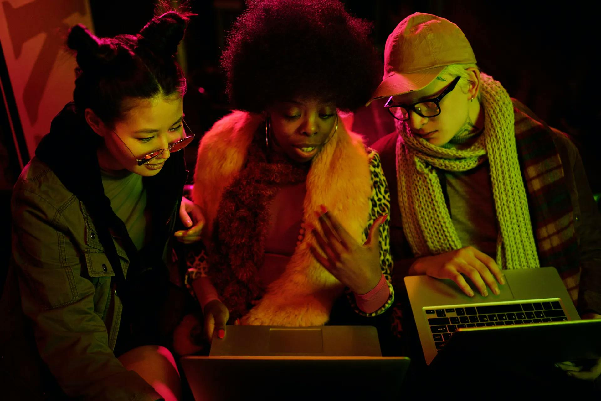 Three women in front of their laptops deep in discussion