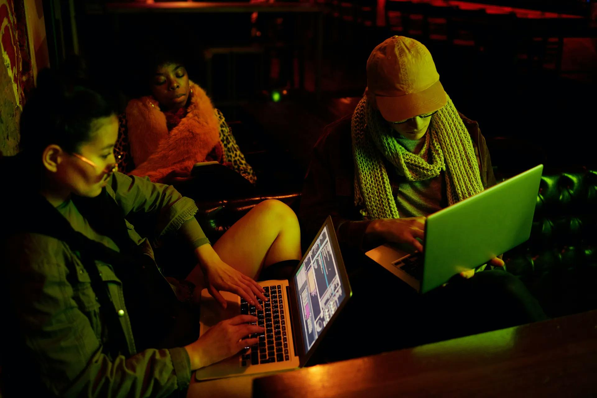 Three women in front of their laptops at work